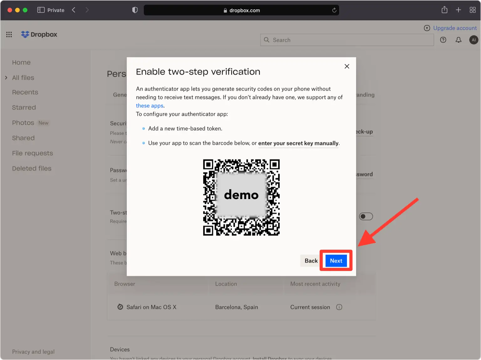 A Dropbox pop-up window displaying a QR code for enabling two-step verification. Instructions are provided to either scan the barcode with an authenticator app or enter a secret key manually. An arrow points to the blue ‘Next’ button to proceed with the setup.